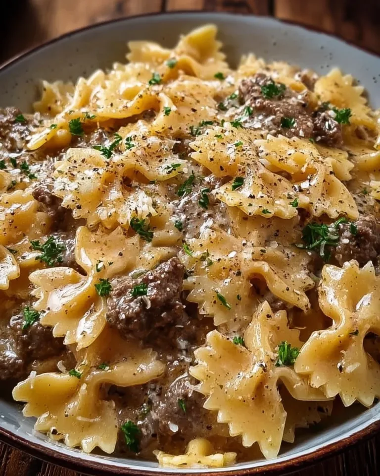 Creamy parmesan garlic beef bowtie pasta dish garnished with parsley.