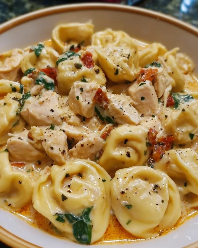 Crockpot Chicken Tortellini in a bowl, garnished with herbs and cheese